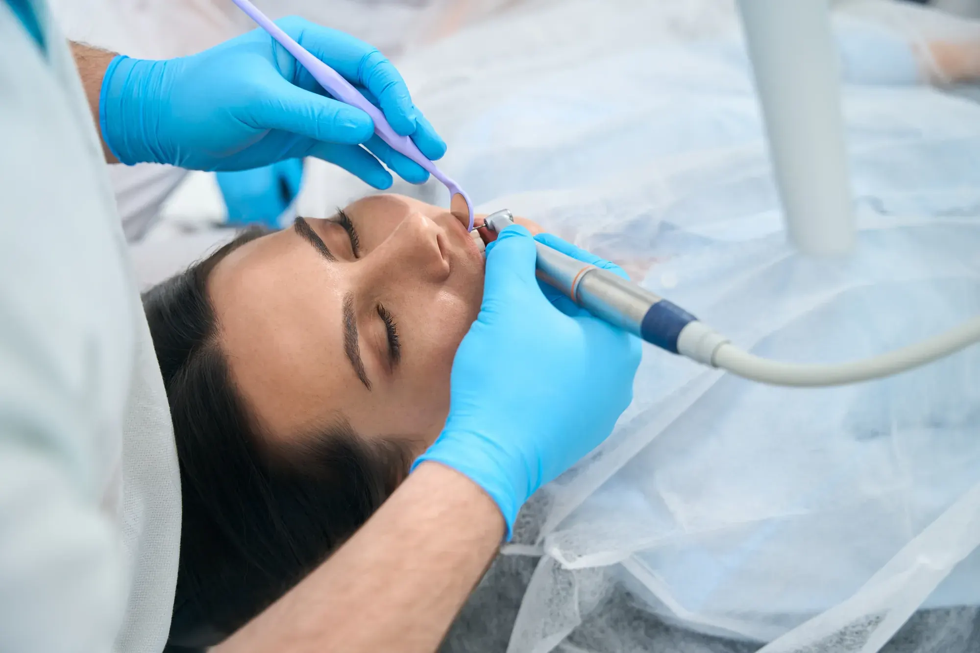 Relaxed patient with eyes closed during gentle, modern root canal therapy at a Tribeca dental office