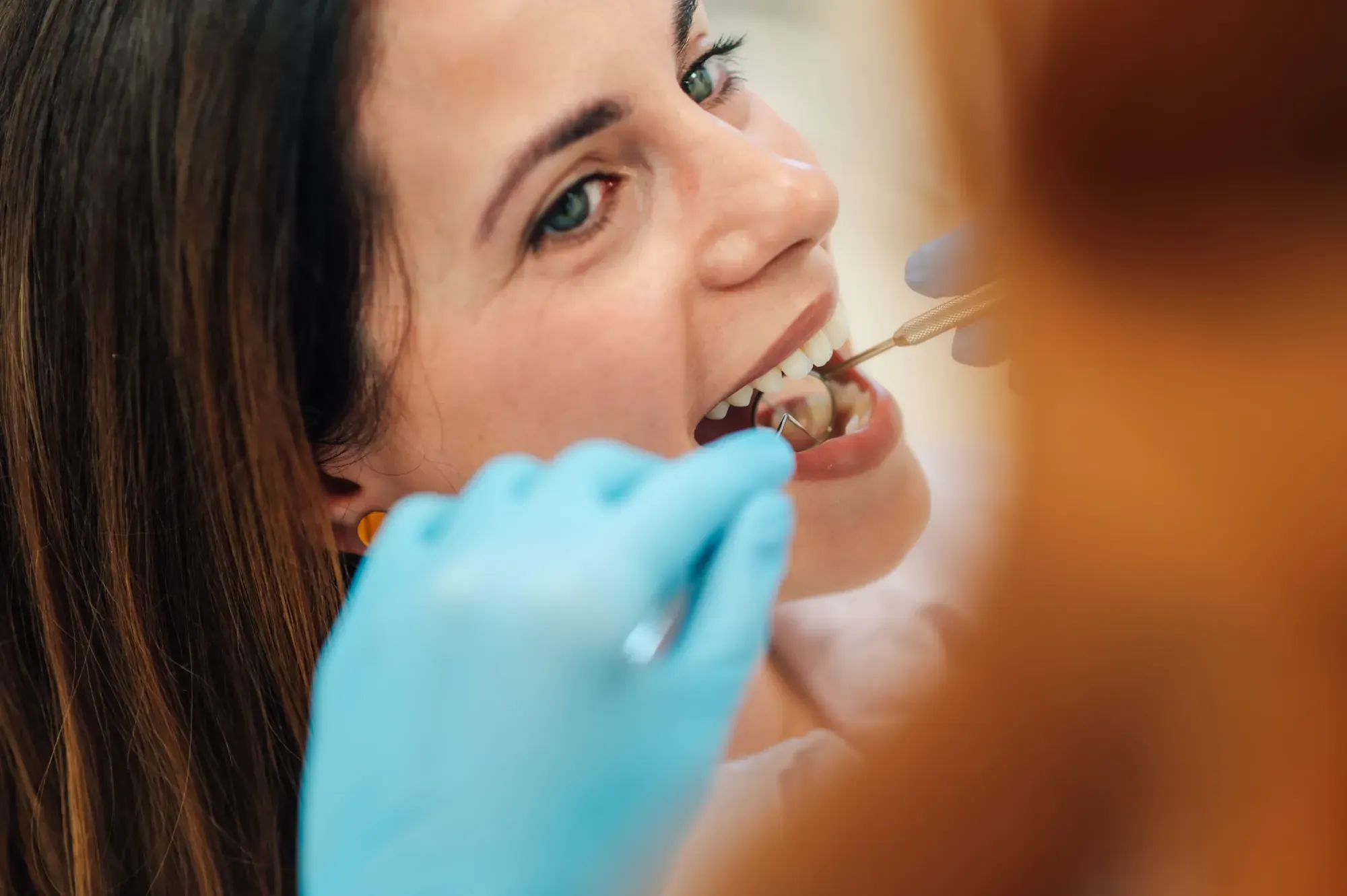 Dentist examining a patient’s tooth before a gentle extraction and bone preservation plan in Tribeca