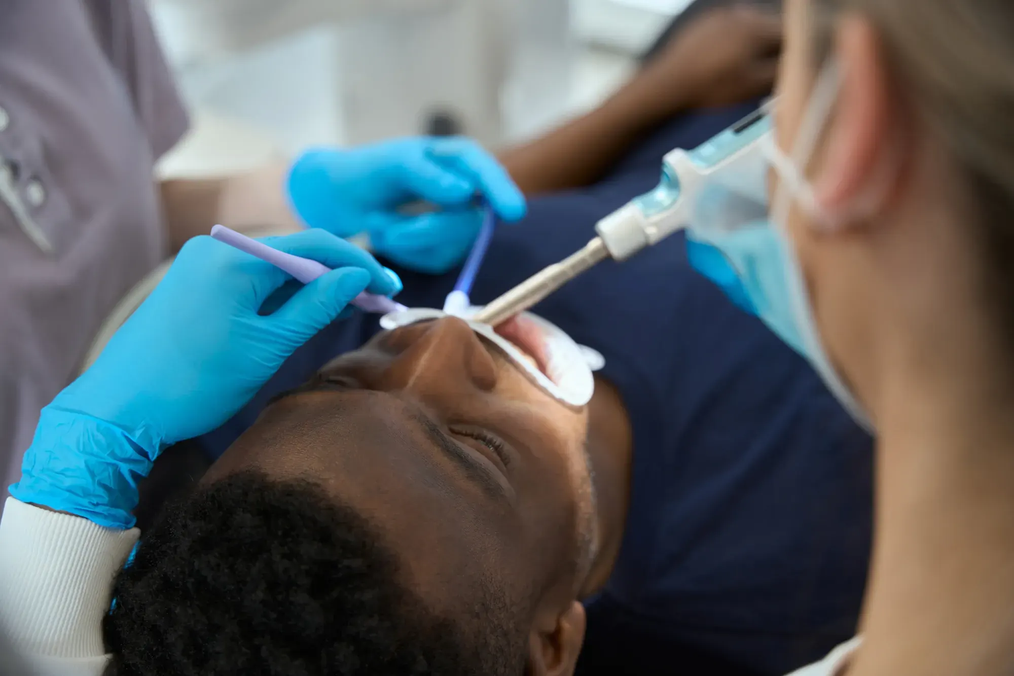 Dentist and assistant performing root canal treatment to save a natural tooth, NYC