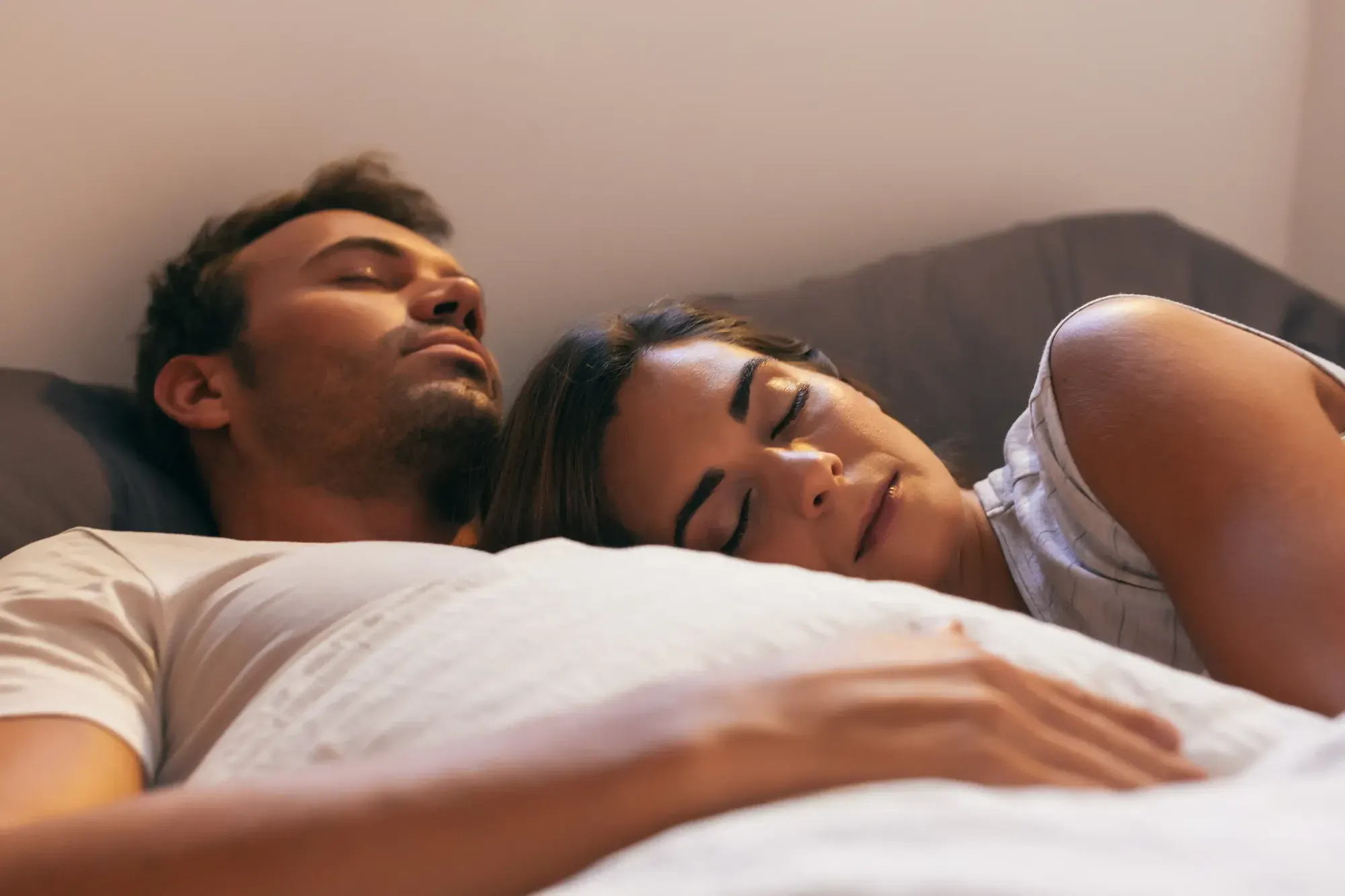 Couple sleeping peacefully in bed, the goal of oral appliance therapy for snoring and sleep apnea in NYC